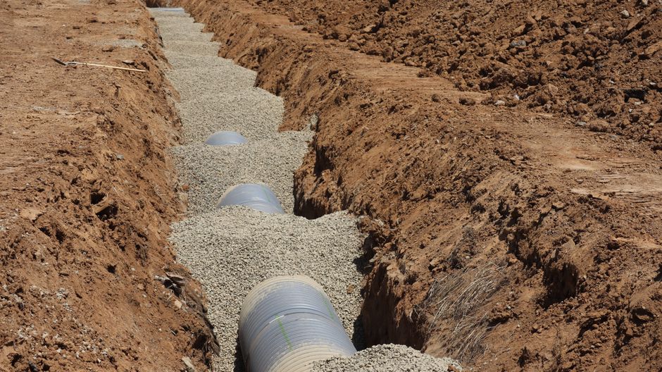 Drainage pipe installation in a trench in Elk Grove, CA — emergency drain and plumbing services for Central Valley homes.
