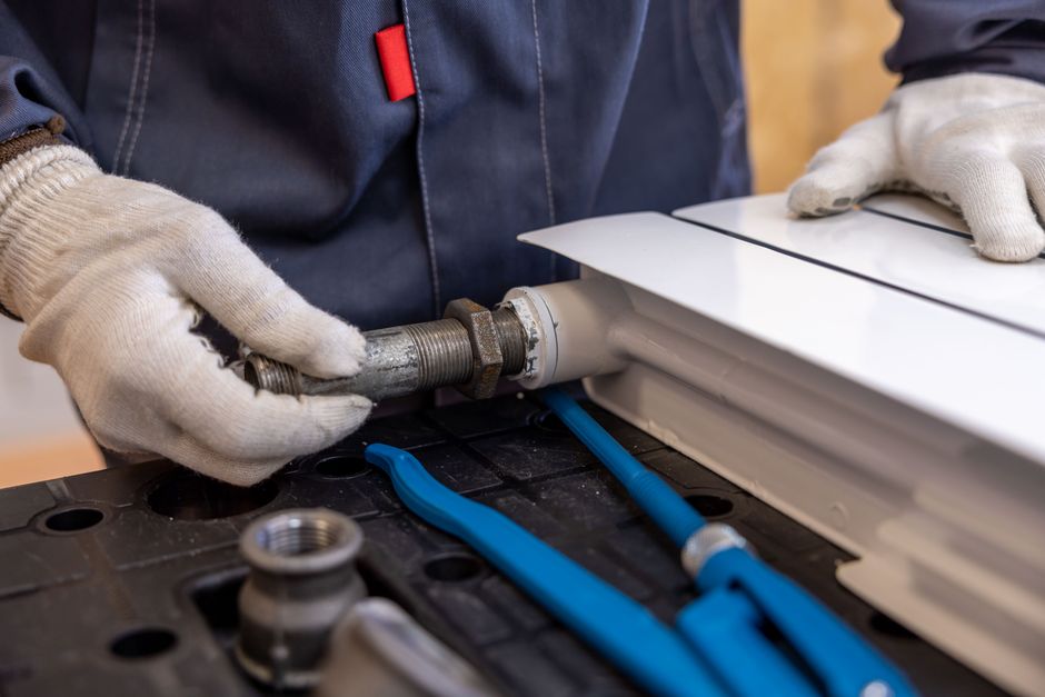 Plumber using specialized tools to fix a pipe connection during an emergency plumbing repair in Modesto, CA