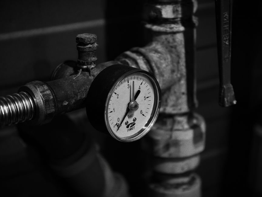 Close-up of industrial plumbing pipes and pressure gauge, representing professional plumber services in Ceres, CA
