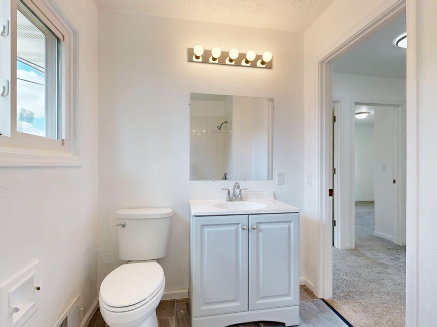 Clean rental bathroom with white fixtures and vanity, representing property management plumbing services in Modesto, CA